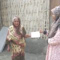 Jovial Hamida receives her card for collecting Ramadan 2023 Food Pack from Islamic Relief teams in Bangladesh.